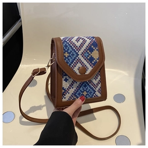 Détail d'un sac bandoulière ethnique tissé avec motifs géométriques et bordure en cuir