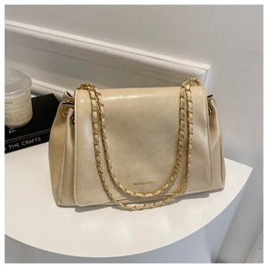 Détail d'un sac vintage beige en cuir avec bandoulière dorée et lettrage FASHION & BAGS