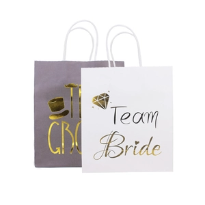 Detail of Team Bride and Team Groom gift bags with elegant gold lettering and rope handles