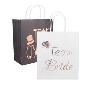 Close-up of Team Bride and Team Groom gift bags with rose gold foil for wedding favors