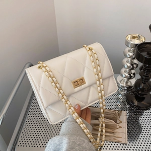Weiße gesteppte Umhängetasche mit goldener Kette und Metallschloss im minimalistischen Look