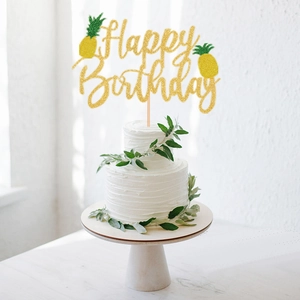 Golden glitter Happy Birthday cake topper with pineapple motifs on a white cream cake
