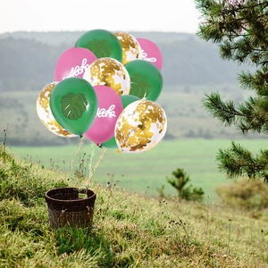 Detail of Hawaii themed balloons with Aloha print, palm leaves and gold sequins for party décor