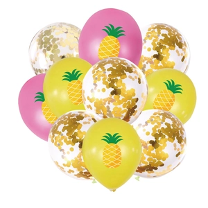 Close-up of pink and yellow pineapple balloons with sparkling gold confetti details