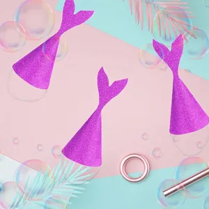 Three purple glitter mermaid tail party hats with elastic bands on colorful backdrop