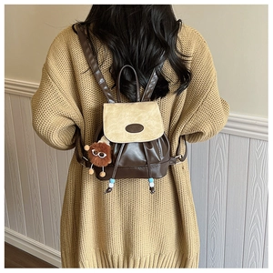 Detail of mini PU leather backpack with contrast flap and cute lion plush charm pendant