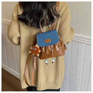 Detailed view of the drawstring backpack with a plush charm and stylish contrast colors