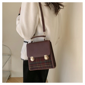 Dettaglio della borsa a tracolla vintage a quadri con finiture in pelle e chiusure dorate