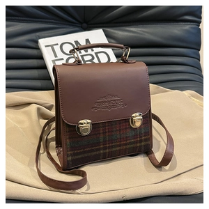 Dettaglio della borsa a quadri vintage con finiture in pelle marrone e chiusure dorate