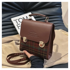 Dettaglio della borsa vintage a quadri con doppi fibbie metalliche e logo a rilievo