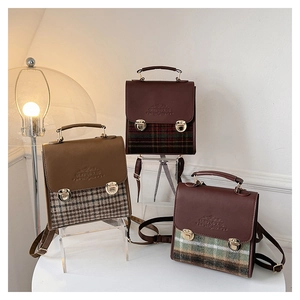 Dettaglio di tre mini zaini vintage a quadri con pelle marrone e finiture in oro