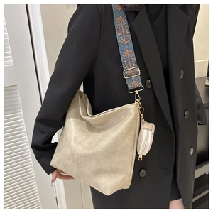 Detail of beige hobo bag with bohemian geometric strap and small round pouch