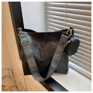 Detail view of black tote bag with vintage ethnic print wide strap and round coin pouch