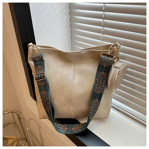 Detail of beige tote bag featuring bohemian geometric strap and mini round coin purse
