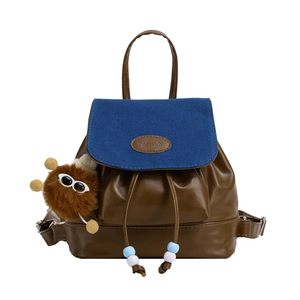 Retro brown leather and blue canvas drawstring backpack with a cute monster keychain