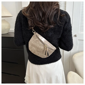 Détail d'un sac de poitrine en cuir mat vintage avec double zip et bandoulière tissée
