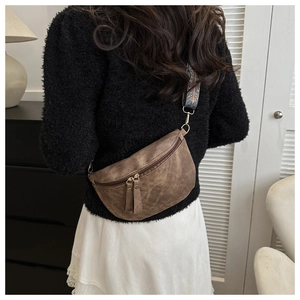 Détail du sac bandoulière vintage marron foncé porté avec sa sangle jacquard ethnique