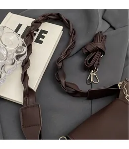 Detail view of dark brown crossbody bag featuring dual interchangeable shoulder straps
