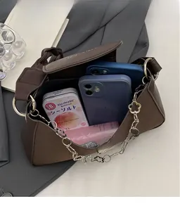 Detail view of large interior capacity for two phones in a brown PU leather underarm bag