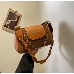 Detail view of brown textured underarm bag featuring a floral metal chain and logo