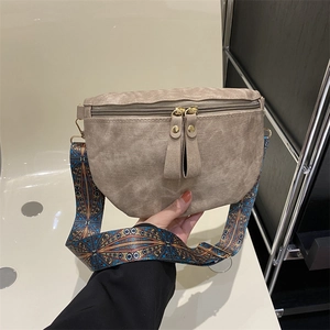 Sac bandoulière demi-lune marron vintage avec une large sangle à motifs géométriques