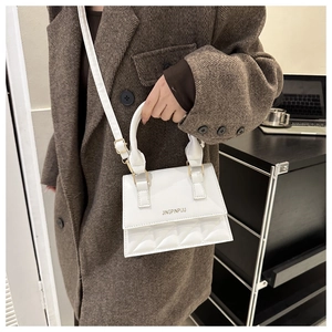 Close-up of white PU leather crossbody bag with quilted pattern and gold letter logo