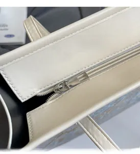 Vue macro détaillée de la fermeture éclair métallique sur un sac à bandoulière crème
