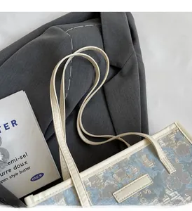 Détail du sac cabas en jacquard bleu clair avec bandoulière en cuir crème confortable