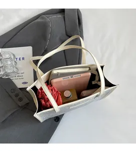 Vue intérieure d'un grand sac fourre-tout bleu clair avec tablette et objets du quotidien