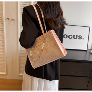 Vue détaillée du sac cabas en jacquard rose avec chaîne en perles et bandoulière en cuir