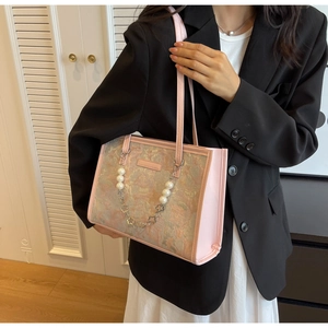 Détail du sac bandoulière en tissu rose avec chaîne de perles et motif de peinture