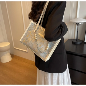 Détail du sac cabas en jacquard bleu avec chaîne de perles et lettrage doré