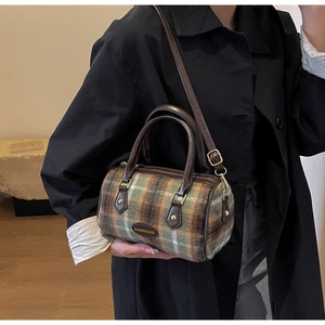 Detail of Boston barrel bag in retro plaid fabric with brown leather handles and strap