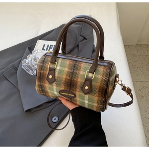 Detail of vintage green plaid Boston bag with leather handles and adjustable strap