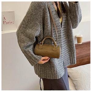 Brown leather boston bag with letter embossing shown in a lifestyle model setting