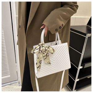 Détail du sac à main matelassé blanc avec foulard imprimé chaîne vintage sur l'anse