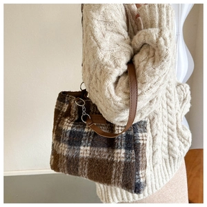 Detail of vintage wool plaid tote bag with brown faux fur texture and leather strap