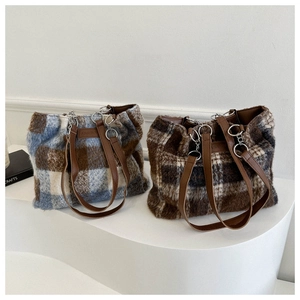 Close-up of large plaid wool tote bags with plush texture and leather handles