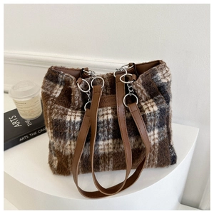 Detail of checkered plush tote bag with FASHION patch and brown leather strap