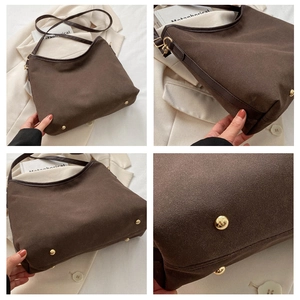 Detail view of large dark brown tote bag showing durable golden metal feet and suede texture