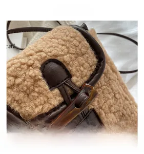 Détail du sac à bandoulière en polaire kaki avec bordure en cuir marron et bouton en corne