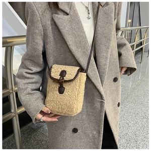 Détail du sac bandoulière en peluche avec boucle en corne et bordure en cuir marron