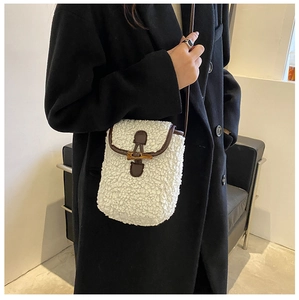 Détail du mini sac bandoulière blanc en peau lainée avec bordure en cuir et bouton en corne