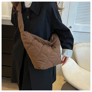Close-up of brown quilted tote bag showing large diamond stitching and soft nylon texture