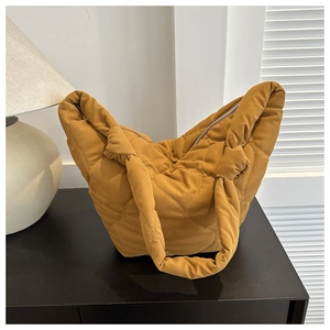 Detail of ginger yellow quilted heart bucket bag with a stylish knotted handle design