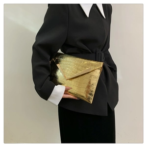 Close-up of golden crocodile texture envelope clutch bag with V-shaped metal clasp