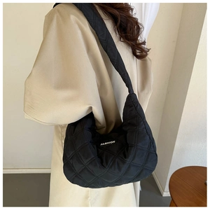 Détail du sac à bandoulière matelassé noir avec étiquette mode et texture en nylon