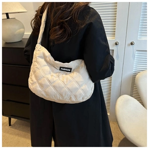 Détail du sac bandoulière matelassé beige avec étiquette FASHION décorative