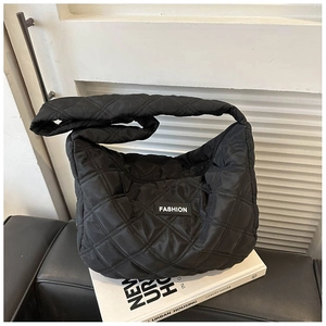 Détail d'un sac à bandoulière en nylon matelassé noir avec étiquette FASHION blanche