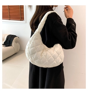 Detail of white quilted half-moon hobo bag showing the soft padded texture and stitching